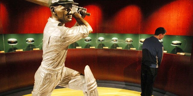 A statue of Australian cricketing great Don Bradman is ringed by Baggy Green caps worn by the famous cricketer, at the Sports Museum at the MCG in Melbourne, on June 2, 2008. A bat used by Bradman and signed by his 1948 "Invincible" team is expected to fetch up to Aus$20,000 at auction this month, an auctioneer said on Friday.