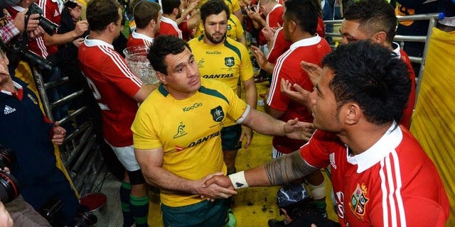 Australian Wallabies flanker George Smith (C) shakes hands with British and Irish Lions centre Manu Tuilagi after the Lions defeated the Wallabies in their third Test, match played in Sydney on July 6, 2013. The Wallabies may have lost the series but Australia did very well financially out of the recent rugby tour by the Lions, a tourism industry body said on Friday.