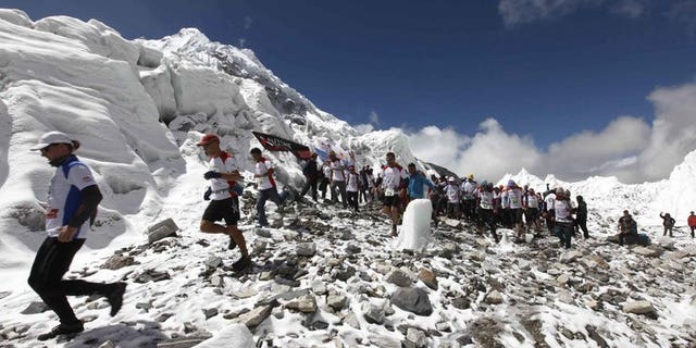 In this handout photograph released on May 29, 2013, marathon participatants are flagged off at Everest Base Camp in Nepal's Solukhumbu district. Nepal's tourism ministry said Friday it plans to exercise tighter control of climbers scaling Mount Everest to make sure they keep the world's highest peak clean and to prevent rows.