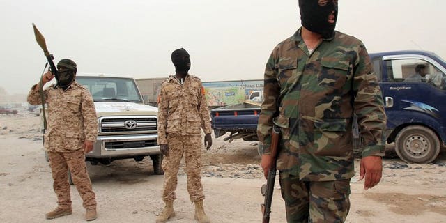 This file photo shows members of the Libyan Rapid intervention force unit patrolling at a checkpoint in Benghazi, on May 16, 2013. A senior police officer was gravely wounded in an overnight bombing in Libya's restive second city, a security official told AFP on Saturday.