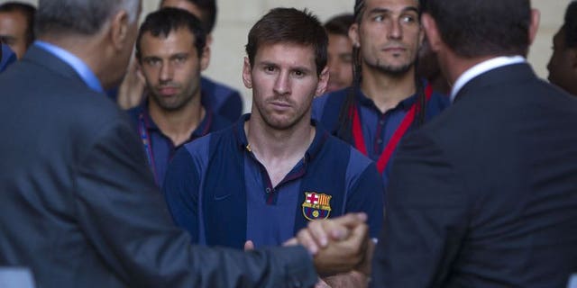 President of FC Barcelona Sandro Rosell (R) and president of the Palestinian Olympic Committee Jibril Rajub (L) shake hands in front of Argentinian forward Lionel Messi (C) at a joint news conference in the West Bank Biblical town of Bethlehem on August 3, 2013.