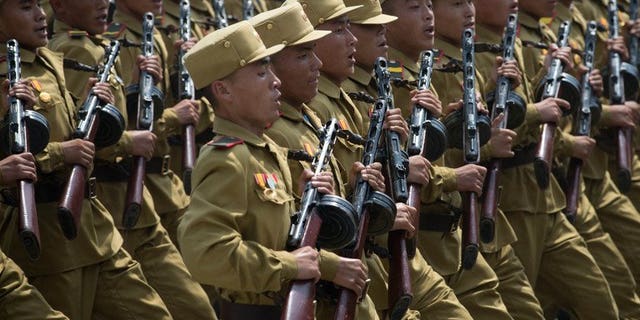 North Korean soldiers march through Kim Il-Sung square during a military parade, marking the 60th anniversary of the Korean war armistice, in Pyongyang, on July 27, 2013. N.Korea has cut short summer military drills to mobilise troops for flood relief efforts after torrential rains left dozens killed and ravaged farmlands nationwide, according to a S.Korean report.