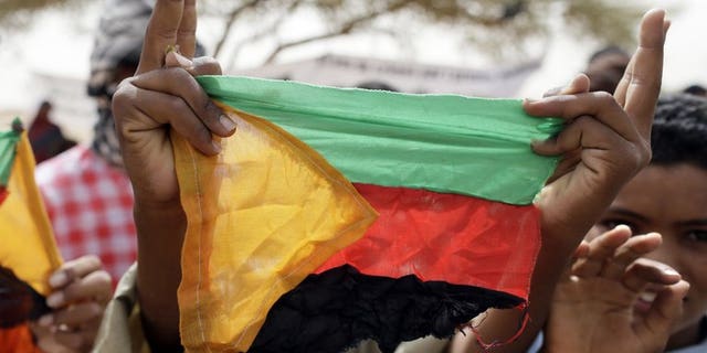 A Tuareg holds the flag of the National Movement for the Liberation of Azawad (MLNA) during a demonstration in Kidal on July 28, 2013. Tuareg rebels will fight Mali's newly-elected rulers if no negotiated solution is reached to grant their northern homeland of Azawad autonomy, a senior Tuareg rebel official warned.
