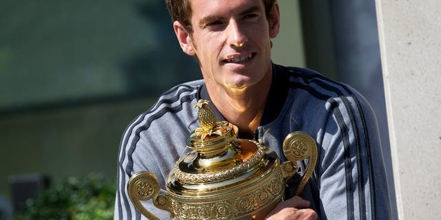 British tennis player Andy Murray poses with the 2013 Wimbledon trophy at the All England Club in Wimbledon, southwest London, on July 8, 2013. Murray admits that try as he might, he cannot keep the excitement and anticipation of his upcoming US Open title defence out of his mind at the Montreal Masters.