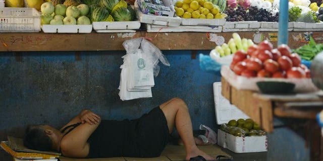 A vendor takes a rest in a market in Shanghai on July 15, 2013. A Chinese vendor's plan to fake his own death at the hands of social enforcers failed when he could not play dead long enough in scorching heat, state media reported Monday.