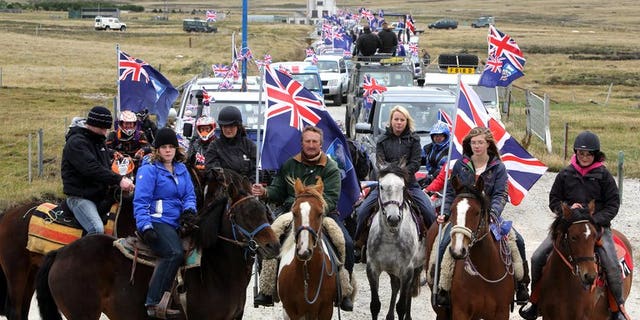 Islanders take part in the "Proud to be British" parade along Ross Road in Port Stanley, Falkland (Malvinas for Argentina) Islands, on March 10, 2013. Sandy Woodward, who commanded the British navy task force that retook the Falkland Islands in the 1982 war with Argentina, has died aged 81, the defence ministry confirmed.