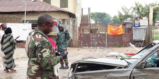 A soldier stands near a damaged car at a scene of an explosion in the Sabon Gari neighbourhood of Kano on July 30, 2013. Two Lebanese suspects alleged to be members of Hezbollah and on trial in Nigeria on terrorism charges told a court Monday they were harshly interrogated by Israeli agents after their arrests.