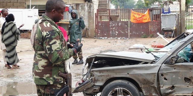 A soldier stands near a damaged car at a scene of an explosion in the Sabon Gari neighbourhood of Kano on July 30, 2013. Two Lebanese suspects alleged to be members of Hezbollah and on trial in Nigeria on terrorism charges told a court Monday they were harshly interrogated by Israeli agents after their arrests.