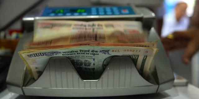A cash counting machine counts Indian rupee notes in Mumbai, on July 31, 2013. The rupee, Asia's worst-performing major currency this year, plunged to a fresh record low against the dollar on Tuesday over concerns that foreign capital could flow back to the United States as the American economy picks up.