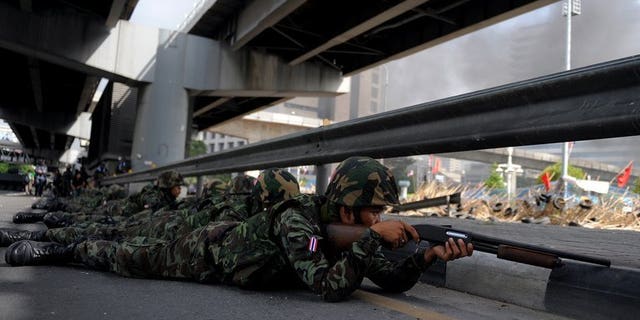 Thai soldiers take position outside the Red Shirt anti-government protesters' camp in Bangkok on May 19, 2010. Six Thais, including a nurse and two rescue volunteers, shot dead while sheltering in a Bangkok temple declared a safe zone during 2010 protests were killed by army bullets, a court ruled Tuesday.