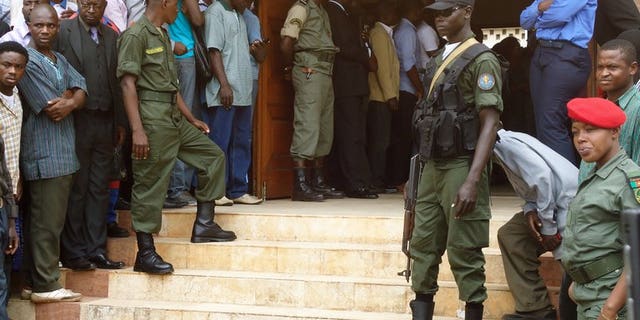 Policemen stand at the entrance of a court in Yaounde on July 16, 2012. A Cameroonian court has sentenced a former health minister to 20 years in prison for corruption over a fake contract to deliver mosquito nets to hospitals, legal sources said.