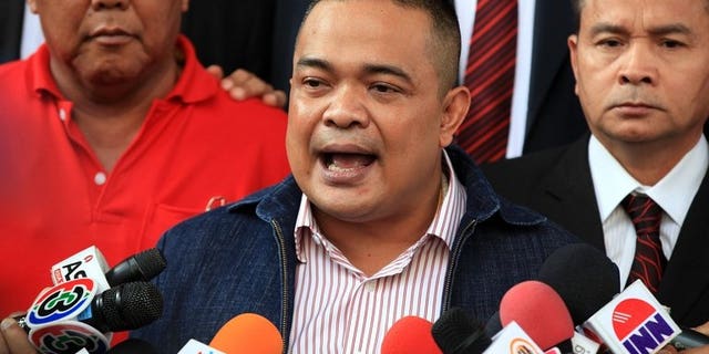 Thai "Red Shirt" leader Jatuporn Prompan speaks to reporters as he leaves a courthouse in Bangkok, on December 14, 2012. Prompan has been cleared of slander over claims that he accused the former premier of sitting incorrectly during an audience with the king.
