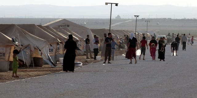 Syrian refugees gather at the Zaatari camp in Jordan, on July 31, 2012. Jordan has denied a UN report that organised crime networks operate in the country's Zaatari camp, which hosts 130,000 Syrian refugees.
