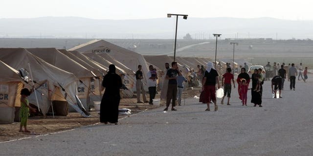 Syrian refugees gather at the Zaatari camp in Jordan, on July 31, 2012. Jordan has denied a UN report that organised crime networks operate in the country's Zaatari camp, which hosts 130,000 Syrian refugees.