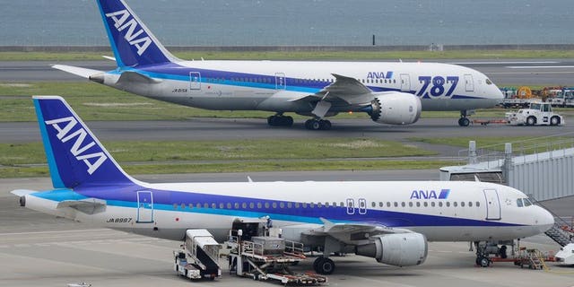 A Dreamliner passenger plane (top) of Japan's All Nippon Airways (ANA) is towed on the tarmac at Haneda Airport in Tokyo on April 30, 2013. ANA said Wednesday it had found defective wiring in a fire-extinguishing system on three of its Boeing Dreamliners, prompting rival Japan Airlines to abort a Helsinki-bound flight.
