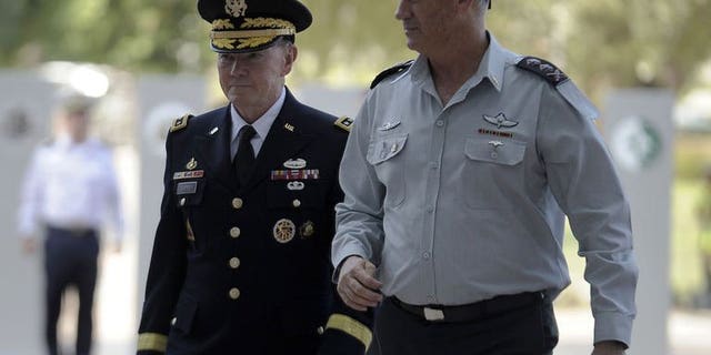 US Chairman of the Joint Chiefs of Staff General Martin Dempsey (L) walks alongside Israeli army Chief of Staff Lieutenant General Benny Gantz during a welcome ceremony in Tel Aviv on August 13, 2013. Iran's nuclear programme was at the centre of discussions on Wednesday between Dempsey and Yaalon, public radio said.