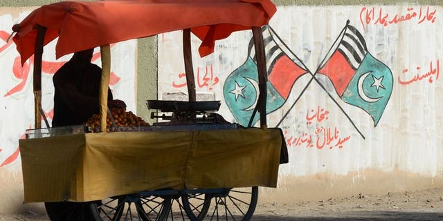 A Pakistani vendor waits for customers near grattifi messages and scrawled flags of Jihad and Ahle Sunnat Wal Jamaat, the "political wing" of a banned militant faction Lashkar-e-Jhangvi in Quetta on March 5, 2013. Pakistan will hang two convicted militants next week, officials said, despite a Taliban warning that it would regard the execution of any of its members as a "declaration of war".