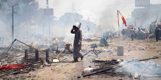 A supporter of Egypt's ousted president Mohamed Morsi walks through the debris following clashes with police in Cairo on August 14, 2013. Egyptian security forces were in "total control" of the main protest camp of supporters of ousted president Mohamed Morsi on Wednesday after a day of deadly clashes, a security official said.