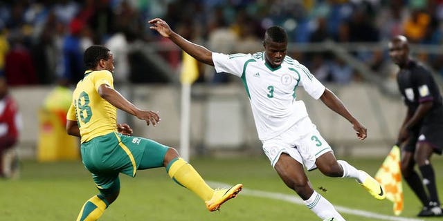 Nigeria's Elderson Echiejile (R) passes the ball away from South Africa's Thuso Phala during the 2013 Nelson Mandela football Challenge friendly match between South Africa and Nigeria at Moses Mabhida Stadium on August 14, 2013 in Durban, South Africa. Nigeria won 2-0.