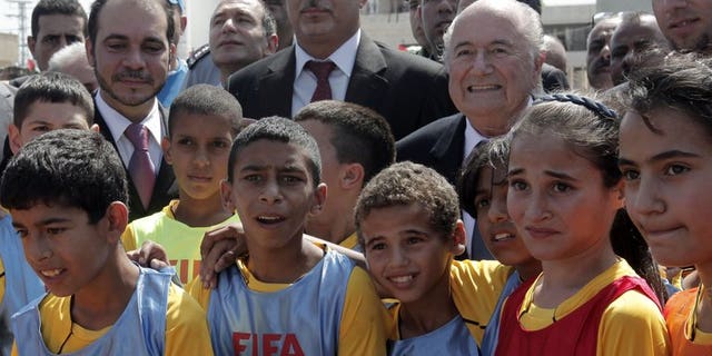 FIFA President Sepp Blatter (centre right), Palestinian Football Association chairman Jibril Rajoub (centre) and FIFA Vice-President Prince Ali bin al-Hussein with Palestinian children in the West Bank town of Tulkarm July 7, 2013.
