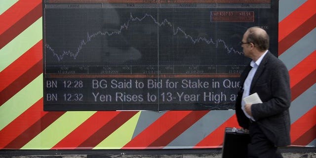A man walks past an electronic display board showing the FTSE 100 share index in London on October 24, 2008. London stocks closed in the red as speculation grew that the US Federal Reserve will start scaling back its stimulus programme as soon as next month.