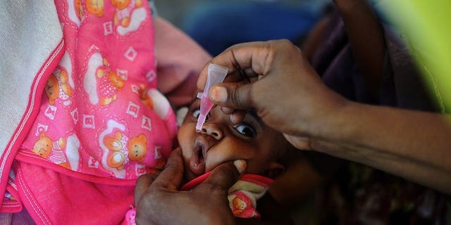 A Somali baby is given a polio vaccination before being given a pentavalent vaccine injection at a medical clinic in Mogadishu on April 24, 2013. Somalia are struggling to contain a dangerous outbreak of the crippling polio virus, with rampant insecurity hampering efforts, the United Nations said Friday.