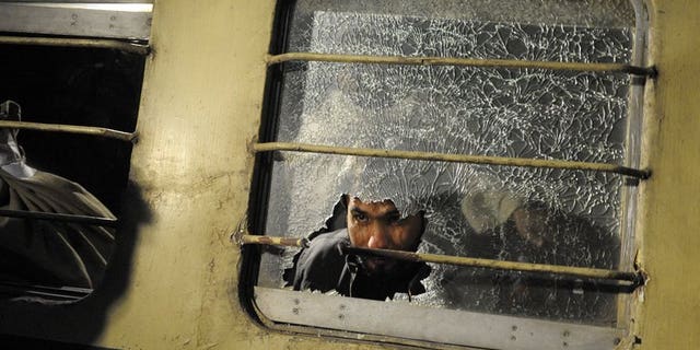 A man looks through a broken mirror on a train after an attack at a railway station in Quetta last year. Unidentified militants killed two people and wounded 24 Friday in a gun and rocket attack on a passenger train in restive southwest Pakistan, officials said.
