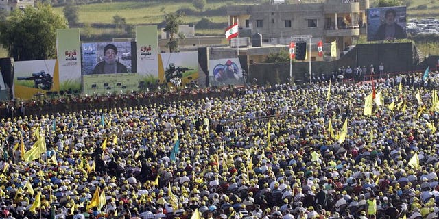 Lebanese supporters of the Shiite Hezbollah movement listen to Hezbollah's leader Hasan Nasrallah delivering a televised speech as they gather in the southern Lebanese village of Aita al-Shaab, on the border with Israel on August 16, 2013 to commemorate the seventh anniversary of the 2006 July-August war between Lebanon and Israel.