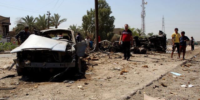 Iraqis inspect the scene of a car bomb attack near the office of Al-Ahad television channel in Baghdad's eastern neighbourhood of Baladiyat on August 15, 2013. Attacks in Baghdad and north of the capital killed seven people on Friday, the latest in spiralling violence authorities have failed to stem despite launching wide-ranging anti-militant operations.