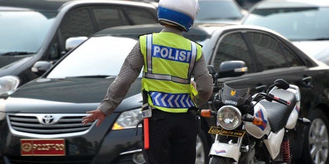 Illustration: Indonesian traffic police control a busy street in Jakarta, on February 21, 2012. Two policemen were killed on the city's outskirts on the night of August 16.
