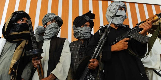 Former Taliban fighters stand with their weapons during a ceremony after joining Afghan government forces in Herat on August 7, 2013. At least 17 civilians have been killed in multiple Taliban attacks in Afghanistan, officials said Saturday, underscoring increasing insecurity for ordinary people as foreign forces complete their withdrawal next year.