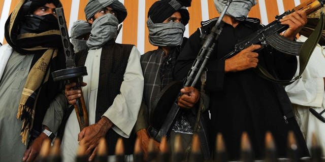 Former Taliban fighters stand with their weapons during a ceremony after joining Afghan government forces in Herat on August 7, 2013. At least 17 civilians have been killed in multiple Taliban attacks in Afghanistan, officials said Saturday, underscoring increasing insecurity for ordinary people as foreign forces complete their withdrawal next year.