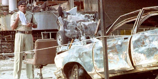 An Indian police officer stands beside a charred automobile outside the Air India building in Mumbai on March 14, 1993 after a series of bombings. Indian police said Saturday they had arrested a top member of a banned militant outfit accused of helping mastermind over 40 deadly bomb attacks across the country, including the 1993 Mumbai blasts.