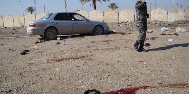 An Iraqi policeman stands at the spot where a suicide bomber blew himself up among a crowd of police recruits on January 18, 2011 in the Iraqi city of Tikrit. Militants killed four policemen and three soldiers in Iraq on Saturday, officials said, the latest attacks in a surge in violence that authorities have so far failed to curb.