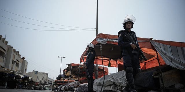 Bahraini police force officers on guard watching the road that runs through the market in the village of Jidd Hafs, west of Manama, on August 14, 2013. Bahrain's prosecutor has said it has launched a probe into riots at a detention centre as an activist said 40 prisoners were wounded as authorities restored order.