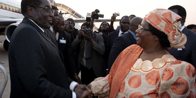 Malawi President Joyce Banda welcomes Robert Mugabe at Kamuzu Airport in Lilongwe on Friday. Southern African leaders opened an annual summit Saturday endorsing disputed elections in Zimbabwe that extended Mugabe's 33-year rule by another five years.