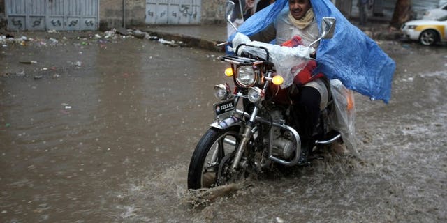 A Yemeni man rides his motorcycle through a flooded street following heavy rains in the capital Sanaa on April 9, 2012. Lightning and flash floods have killed 50 people in Yemen since Friday, including 27 who died when a torrent washed away a wedding convoy, local officials said Saturday.