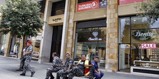 Members of the Internal security forces sit outside the Turkish Airlines offices in downtown Beirut on August 12, 2013. Lebanese authorities have arrested three suspects and charged them in connection with the abduction of two Turkish Airlines pilots, a judicial source told AFP on Saturday.