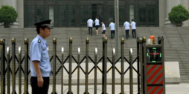 Police stand guard outside the Intermediate People's Court where Chinese politician Bo Xilai was indicted and his case expected to be heard in Jinan, Shandong Province on July 25, 2013. China's former top economic policymaker Liu Tienan has been placed under judicial investigation for suspected bribe taking, state media reported on Sunday.