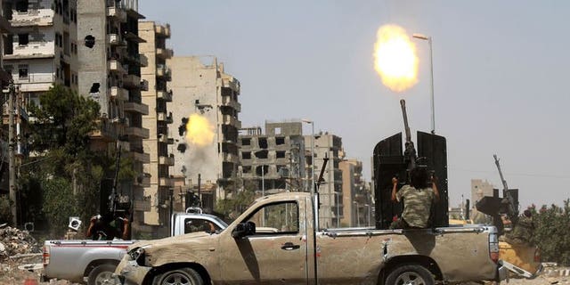 A Syrian rebel fires as a regime fighter jet flies overhead in Syria's eastern town of Deir Ezzor, on August 17, 2013. Opposition leader Ahmad Jarba said Syria is now being run by regime allies Iran and Lebanon's Hezbollah, with President Bashar al-Assad out of the picture, in an interview published Sunday.