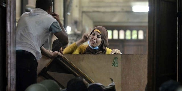 An Egyptian woman talks to policemen from the inside of Cairo's Al-Fath mosque where Islamist supporters of ousted president Mohamed Morsi held up on August 17, 2013. Qatar's foreign minister said Monday his country had never given aid to Egypt's Muslim Brotherhood and that all assistance went to Egypt as a whole.