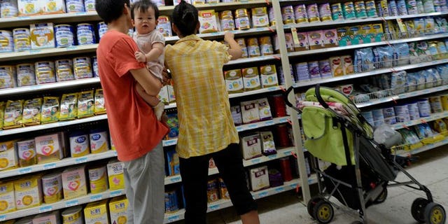 A Chinese family buys baby milk powder at a store in Beijing on August 7, 2013. The latest scare comes after an ingredient used in some baby formula contained a potentially deadly bug.