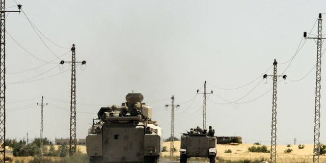 Egyptian soldiers and a military helicopter are seen in the area near the Rafah border crossing, on May 21, 2013. Militants fired rocket-propelled grenades at two buses packed with Egyptian policemen in Sinai, killing 24 in the deadliest attack of its kind in years.