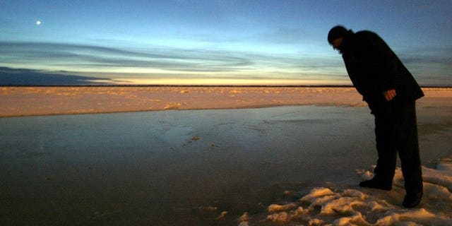 File picture shows a local resident looking into the Amur river in Khabarovsk, eastern Russia, December 24, 2005. Floods on the Amur River in Russia's Far East broke historic records Monday as authorities evacuated over 19,000 people from affected areas and warned of a further rise in water levels.