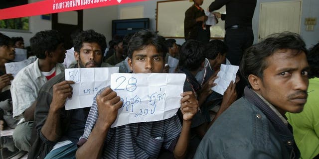Rohingya migrants sit outside a police station before being transported to Thai police immigration on January 31, 2009. On Tuesday dozens escaped from a Thai immigration centre, police said.