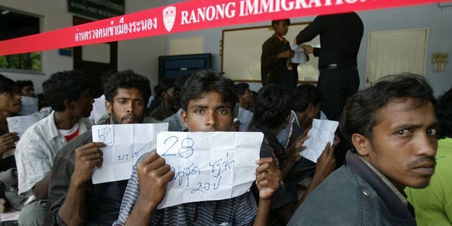 Rohingya migrants sit outside a police station before being transported to Thai police immigration on January 31, 2009. On Tuesday dozens escaped from a Thai immigration centre, police said.
