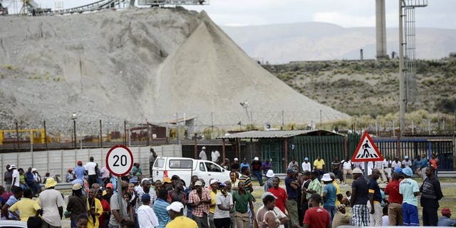 Anglo American Platinum workers who downed tools gather outside the Khomanani shaft in Rustenburg on January 16, 2013. Around 2,000 mineworkers converged at an Anglo American Platinum mine in South Africa's restive platinum belt over plans by the world's top producer to cut 6,900 jobs amid unrest in the sector.