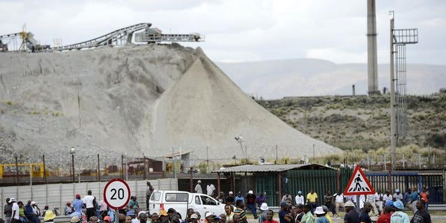 Anglo American Platinum workers who downed tools gather outside the Khomanani shaft in Rustenburg on January 16, 2013. Around 2,000 mineworkers converged at an Anglo American Platinum mine in South Africa's restive platinum belt over plans by the world's top producer to cut 6,900 jobs amid unrest in the sector.