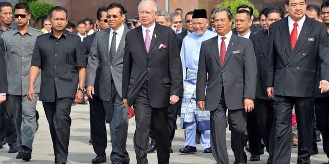 Malaysian Prime Minister Najib Razak (C) flanked by his deputy Muhyiudding Yassin (2nd R) arrives to welcome Malaysian students studying in Egypt at the VVIP terminal in Kuala Lumpur on February 7, 2011. Malaysia will begin evacuating its 3,300 students from Egypt beginning Tuesday night after days of deadly clashes that have killed nearly 900 people, according to a government official.