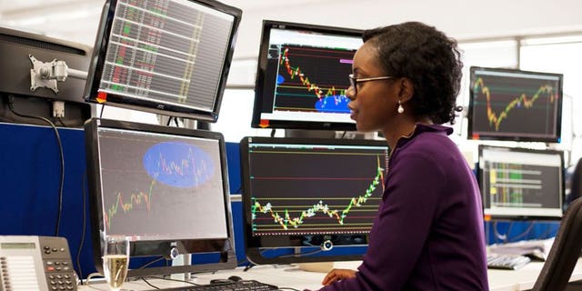 A woman takes part in a trader training programme in London. London shares opened lower on Wednesday on a technical adjustment as more shares went ex-dividend.
